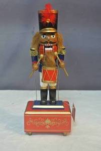 lot 187 image: Nutcracker that has music box and his arms move to the music about 12 inches tall