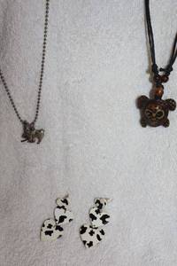 lot 118 image: Jewelry, animal themed Cowskin pattern earrings, llama necklace, and turtle with skull turtle shell necklace