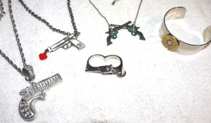lot 208 image: Jewelry Gun pendant necklaces, double finger ring, and ammo style bracelet