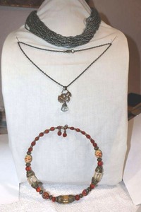 lot 241 image: Glass bead jewelry Metallic green multi strand bead necklace, Clear bead pendant, antiqued gold and red bead stretch necklace