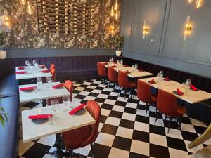 lot 1 image: WOW  Full Wraparound Restaurant Table & Seating  w 7 Piece Sectional Blue Bench Seating, 7 Solid Marble Top Tables, 9 Orange Velvet Chairs & Place Settings For 18 People