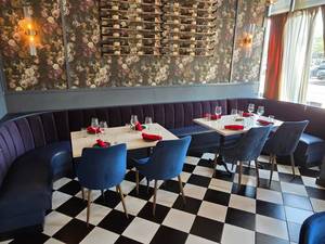 lot 12 image: WOW  Full Wraparound Restaurant Table &amp Seating  w 3 Piece Sectional Blue Bench Seating, 2 Solid Marble Top Tables w Double Cast Iron Spindle Base, 4 Chairs &amp Place Settings For 8 People.&nbsp Tables Measure 48 x 30