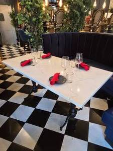 lot 57 image: Long Solid Marble Table w Double Cast Iron Spindle Base & Place Settings w 4 People