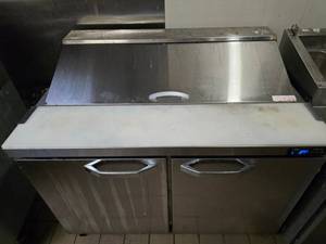 lot 34 image: BlueAir Stainless 48 Refrigerated Prep Table (Model BLPT48-HC).&nbsp UNIT ROLLS FOR EASY REMOVAL.