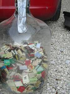 lot 161 image: large glass water jug full of match books