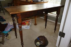 lot 15 image: Vintage or antique solid wood table. Features one drawer with ceramic pull knob. Sheraton style table legs with slender point as shown.