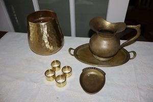 lot 30 image: Brass items pitcher and tray, pocket change dish, hammered vase and solid heavy napkin rings.