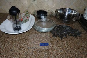 lot 176 image: Kitchen serving platter, Pyrex bowl, colander strainers, salad dressing mixer pourer and trivet