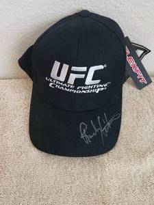 lot 53 image: UFC black fitted hat signed by Randy Couture. It was signed at Walter Reed Hospital - Celebrities would visit the injured. My brother was there for a few months