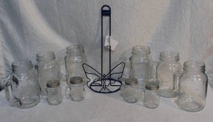lot 91 image: Dolly Parton mason jar glasses with handles and 2 sets of Dolly Parton mason jar salt and pepper shakers and a dolly paper towel holder