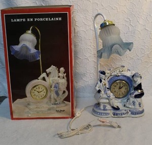 lot 143 image: vintage porcelain lamp with a clock, featuring a colonial or Victorian style.