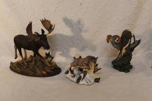 lot 243 image: The figurine on the left is a moose with large antlers The figurine in the center is a bobcat or lynx.The figurine on the right is a bighorn sheep. See all pictures
