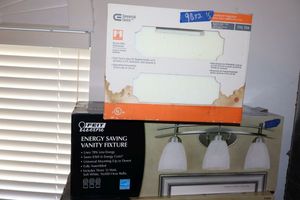 lot 98 image: Light fixtures ceiling mount fixture and vanity fixture (Both still in original packaging)