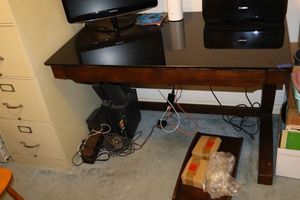lot 120 image: Whalen desk with black glass top. Hard drive stand hasnt been assembled. Not the contents.