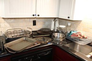 lot 94 image: Kitchen cooking pans, roaster, towel holders, glass juice pitcher, and dish drying rack