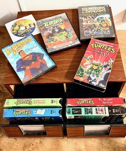 lot 297 image: Seven (7) Vintage Teenage Mutant Ninja Turtle VCR Tapes &amp DVDs W8 Episode Superman Festival DVD and Dungeon &amp Dragons Beginnings 9 Episode DVD - Includes Vintage 1989 Addn Stac VCR Tape Storage Case W Drawers