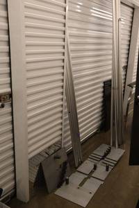 lot 12 image: Aluminum pipe and drape - frame poles and Heavy bases (Black drapes were found in lot 63 with tablecloths)