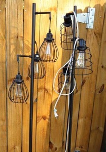 lot 124 image: Two Black floor lamps with cage light globes