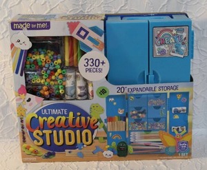 lot 26 image: Made By Me Ultimate Creative Studio Craft Kit. This kit includes over 330 pieces of crafting materials such as beads, fuzzy sticks, glitter poms, and more unopened.