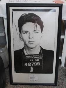 lot 154 image: framed art print of a mugshot of Frank Sinatra. About 38 inches tall and 23 inches wide
