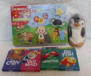 lot 349 image: Cocomelon puzzle card games and a penguin plushie all unopened