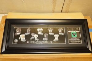 lot 34 image: Oakland Raiders evolution of team uniforms wall plaque 25x10
