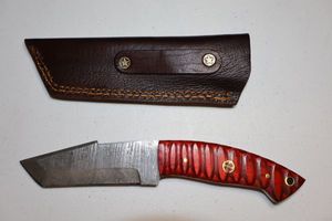 lot 250 image: 3.5 blade Tanto knife with leather sheath.  Red wood grain handle.
