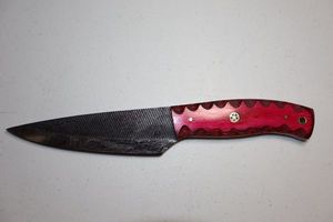 lot 255 image: 5 blade hunting knife with textured black top.  Pinkred wood grain handle.
