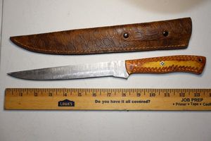 lot 262 image: 8.5 blade fillet knife with leather sheath.  Wood tone handle.