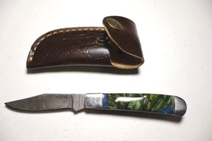 lot 9 image: Pocket knife with leather sheath.  Bluegreen resin handle.