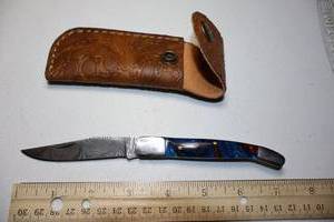 lot 16 image: Folding Pocket knife with leather sheath. Red and blue resin handle.