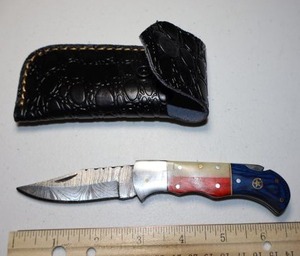 lot 19 image: Texas flag Folding Pocket knife with leather sheath.