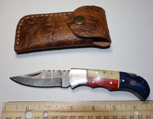 lot 21 image: Texas flag Folding Pocket knife with leather sheath.