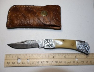 lot 29 image: Folding Pocket knife with leather sheath.  Ivory colored handle.