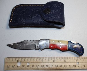 lot 30 image: Texas flag Folding Pocket knife with leather sheath.
