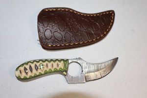 lot 109 image: Skinning knife with finger hole and sheath
