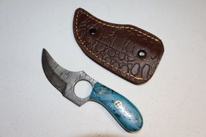 lot 112 image: Skinning knife with finger hole and sheath