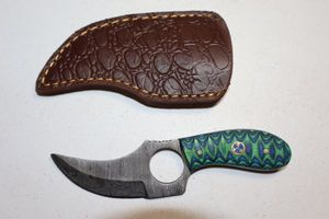 lot 210 image: Skinning knife with finger hole and sheath