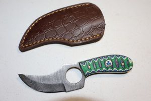 lot 211 image: Skinning knife with finger hole and sheath