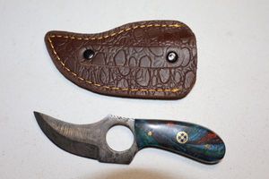 lot 280 image: Skinning knife with finger hole and sheath