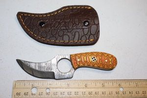 lot 390 image: Skinning knife with finger hole and sheath