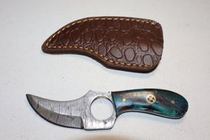lot 357 image: Skinning knife with finger hole and sheath