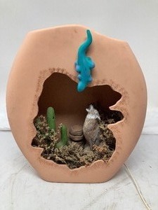 lot 233 image: Sandstone cutout that lights up. Southwestern theme includes a wolf, cactus, Blue lizard, rocks, & greenery