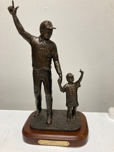 lot 75 image: LEGACY TEXAS TECH UNIVERCITY FROM DI ALUM.COM. FATHER AND SON, FANS OF TEXAS TECH, RAISING THEIR HANDS IN A #1 SALUTE. THE BRONZE FIGURE IS MOUNTED ON A WOOD BASE. 12T x 7L x 5W