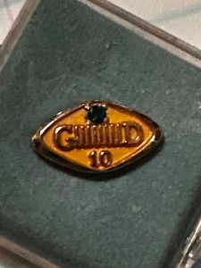 lot 253 image: 10K vintage General Dynamics 10 year pin with emerald stone