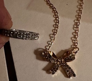 lot 192 image: NEW Silvertone band with zircon and gold bow necklace