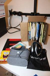 lot 86 image: Post-it notes, note pads, View VR headset, and Velodyne headphones
