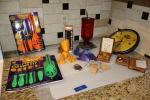 lot 46 image: Plastic baking mats, hummingbird feeder, Pumpkin carving kits, and toys
