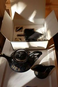 lot 65 image: Black and gold porcelain tea pot, creamer, and Lenox S&P set