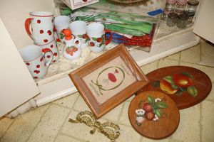 lot 165 image: Strawberry themed lot mugs and placemats, dome butter dish, and strawberry candle